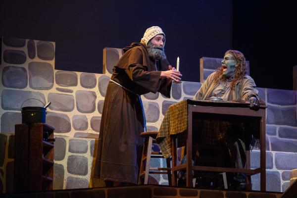 student on stage in Young Frankenstein, one standing one sitting at a desk 