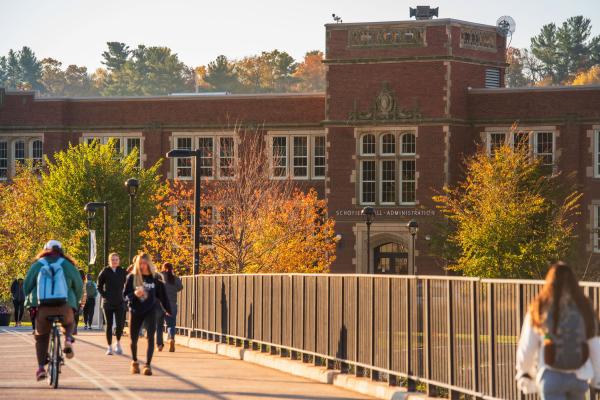 students crossing the footbridge toward Schofield Hall, fall 