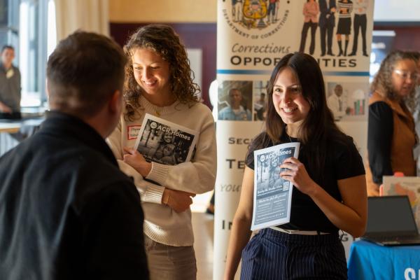 two students at Health Career Fair talking to table reps