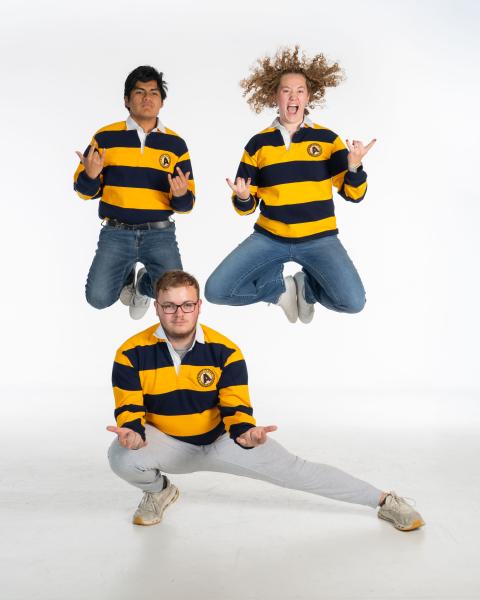 three campus ambassadors doing silly studio shots in striped shirts 