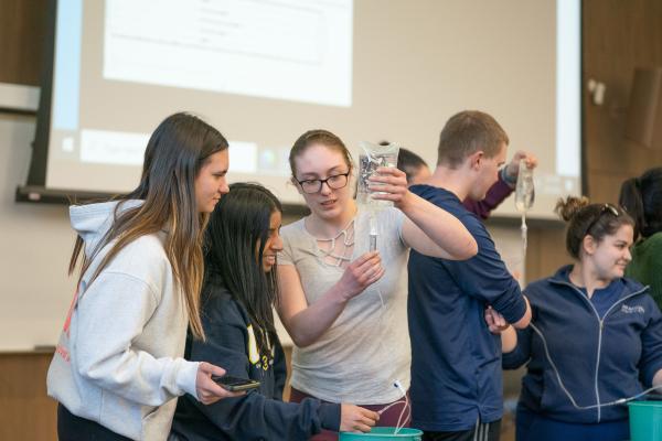 Students holding IV bag in Medical Academy session 