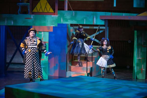 Group of wildly costumed characters greet Eurydice 