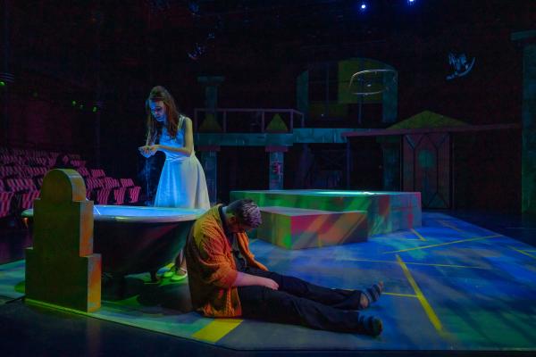 Eurydice touches the river as her father lays slumped on the floor