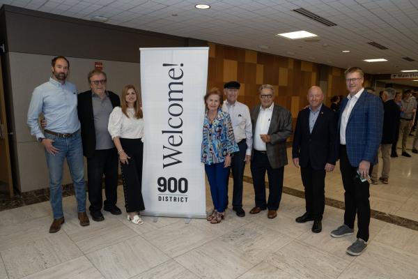 Carolyn and John Sonnentag, center, pose with other supporters of the 900 District project alongside Dr. Tim Nelson, right, inside the former Sacred Heart Hospital building on June 23, 2026.