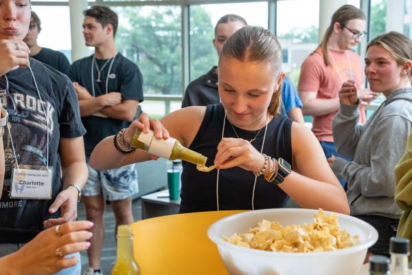 Student sampling chips and hot sauce 