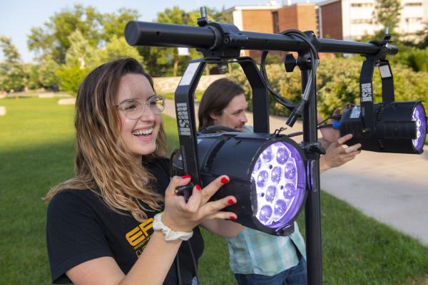 Maria Derrider operating stage lighting for campus mall concert