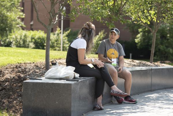 Cedar Marie talking to new faculty person outside in campus mall