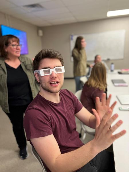 student with vision altering accessibility glasses on