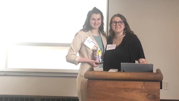 two female students at a podium