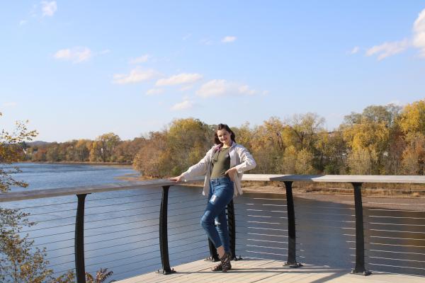 female student posing for portrait along the Chippewa River waterfront on campus