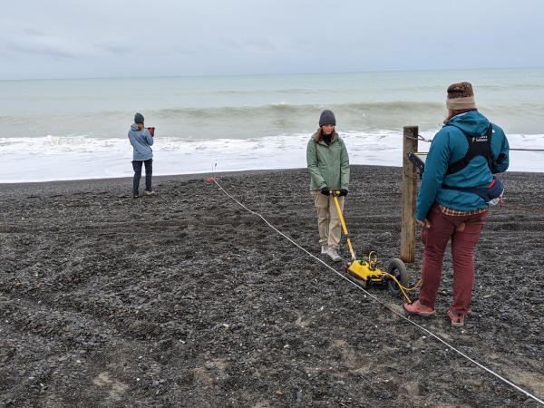 students on a rocky beach using geothermal radar in New Zealand