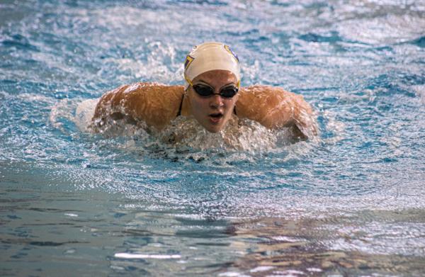Bella Thovson swimming for Blugolds