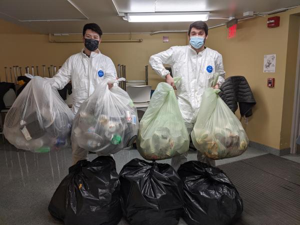 students in hazmat gear sorting food waste and trash in research project about waste