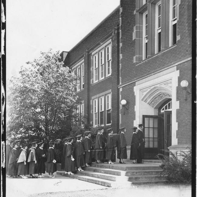 graduates walking into Schofiled for Commencement