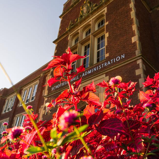 Schofield building next to flowers in the Fall