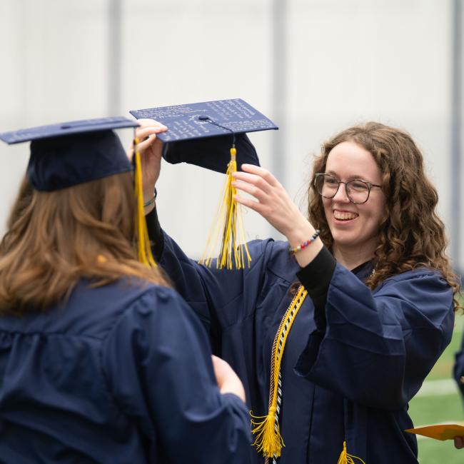 girls adjusting caps on graduation day 