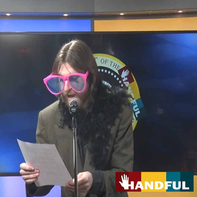 The host of Handful in big glasses introduces a skit