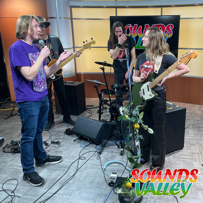 A student interviewing a band for an episode of Sounds of the Valley