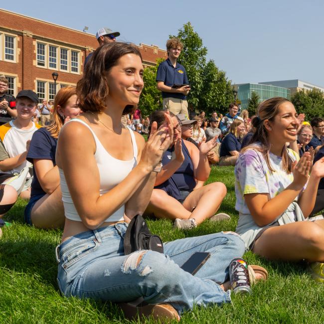 Students clap while smiling during Welcome Week.