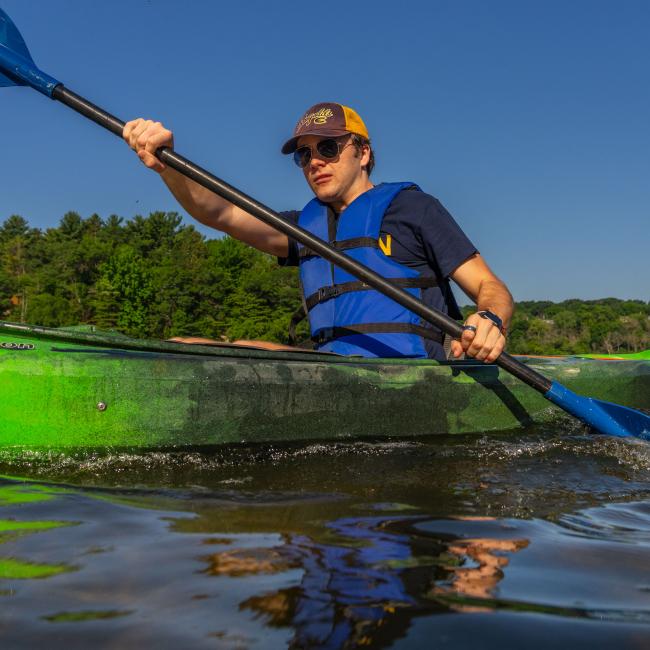 A student kayaks across the Chippewa River
