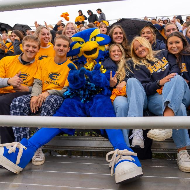Blu poses with a bunch of Blugolds in the stands during UWEC's first football game of 2025.