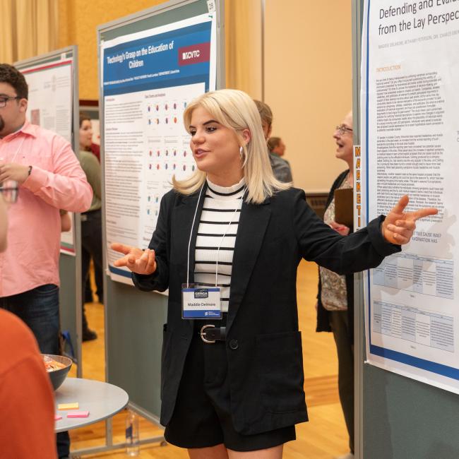 A marketing student presents her poster project at CERCA.