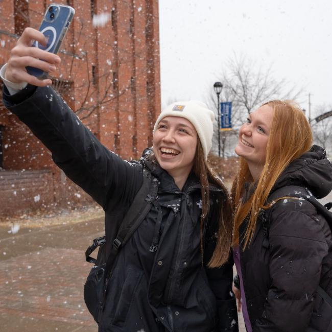 Students take a selfie during the first snowfall of November 2025.