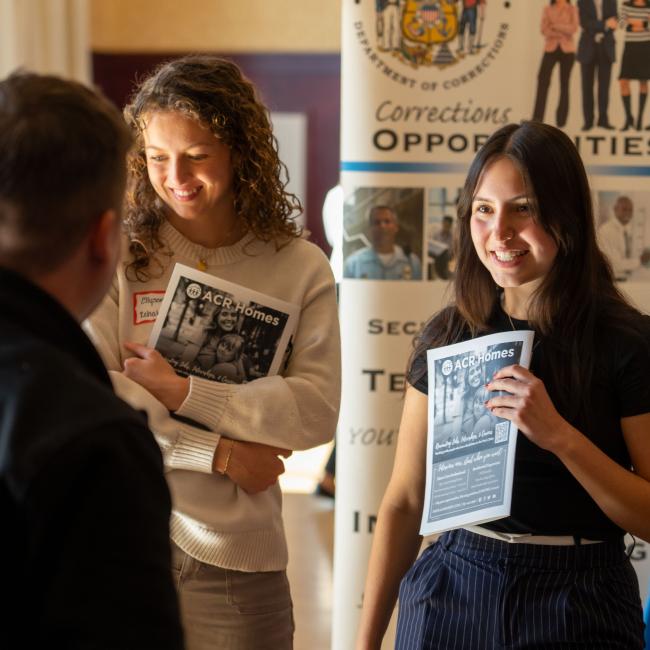 two students at Health Career Fair talking to table reps