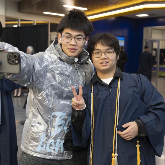Students take a selfie on the day of Commencement. 
