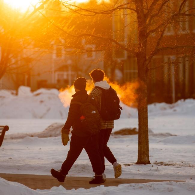 The rising sun shines on students walking to class on a cold January day.