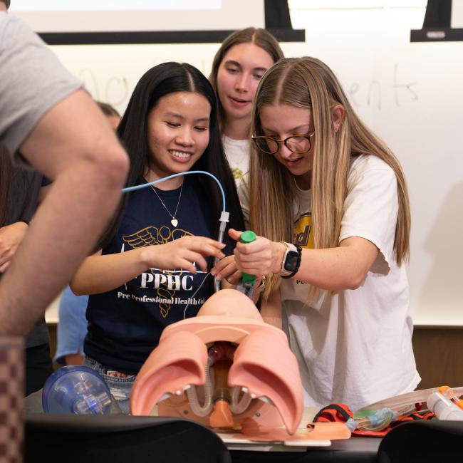 Pre-Professional Health Club students practice their technique on a manikin.