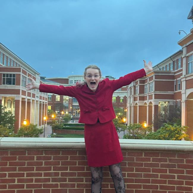 Austyn Clemen in red standing at dusk in front of UW-Madison