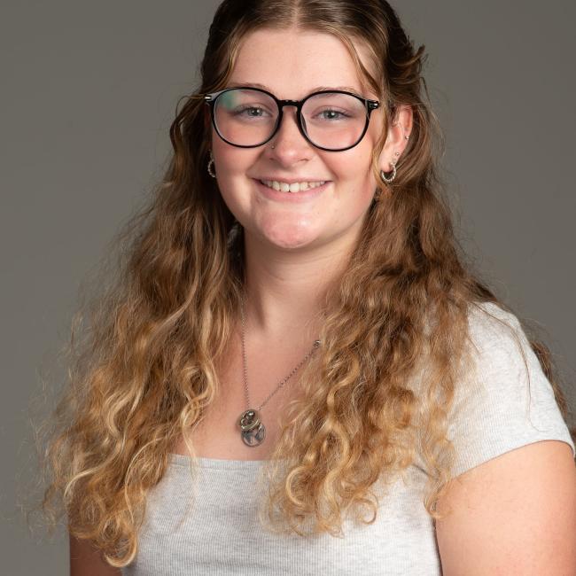 young woman with glasses and curly blonde hair