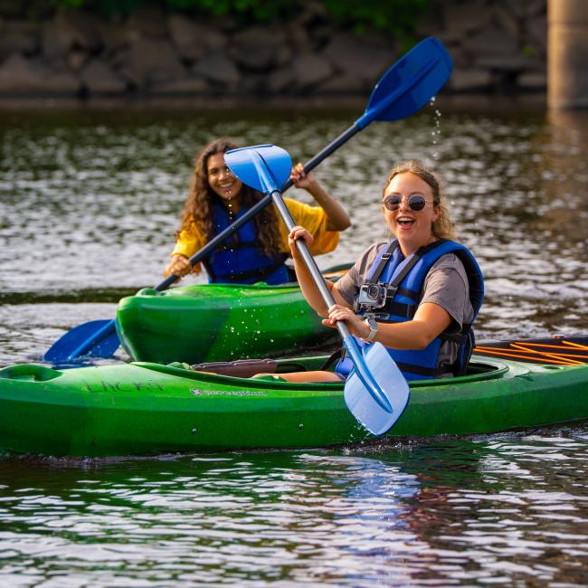 Students smile while kayaking the Chippewa River.