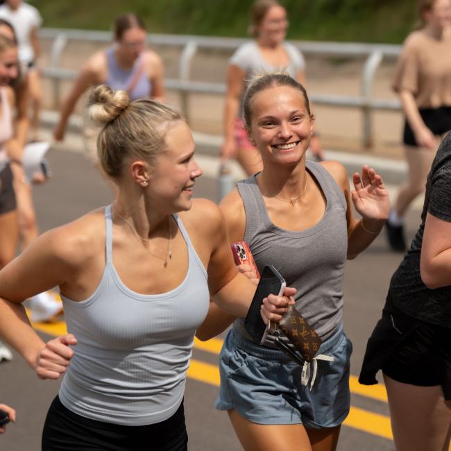 Students smile to the camera while Running The Hill, an annual tradition at UWEC.