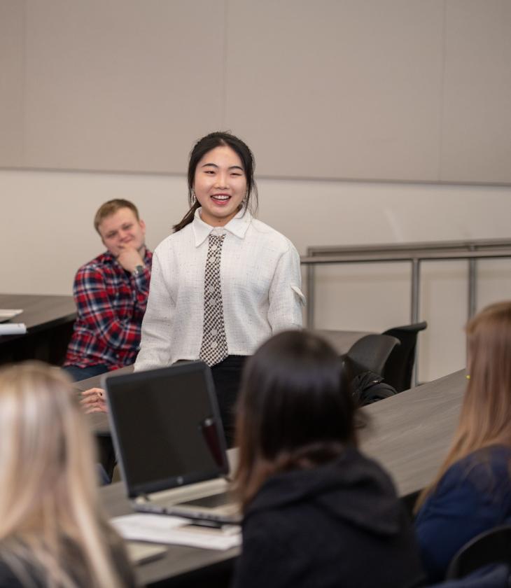 student standing and speaking in Finance class