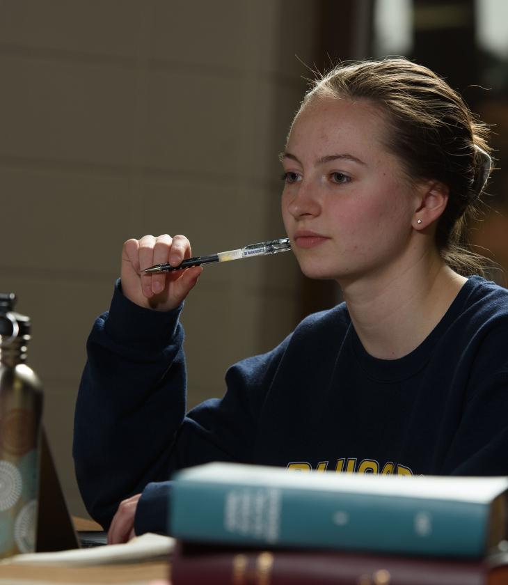 female student pensive at a library table