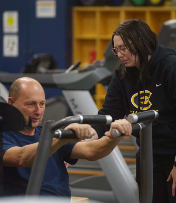 student working with client in workout class