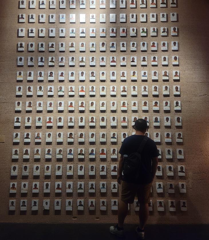 student in front of a large memorial wall