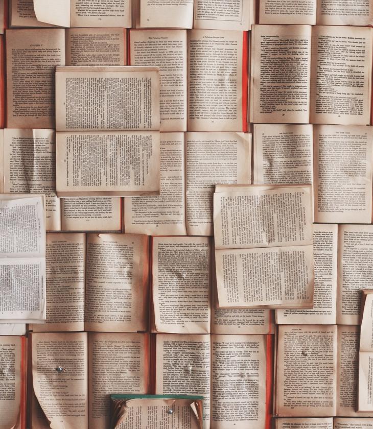Books laying flat open in a pile