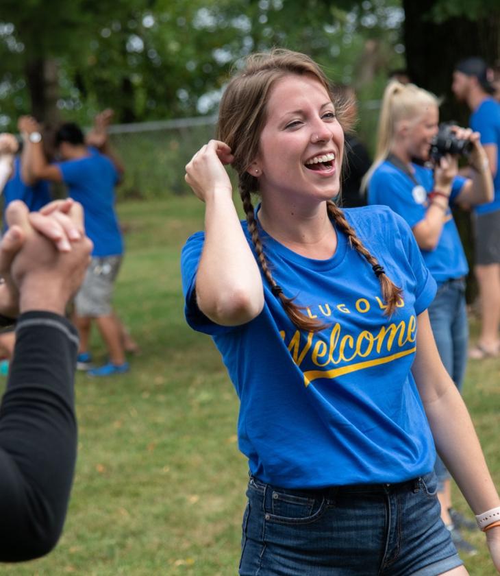 A student in BluGolds welcome shirt participating in an outdoor event for incoming transfer students at UWEC