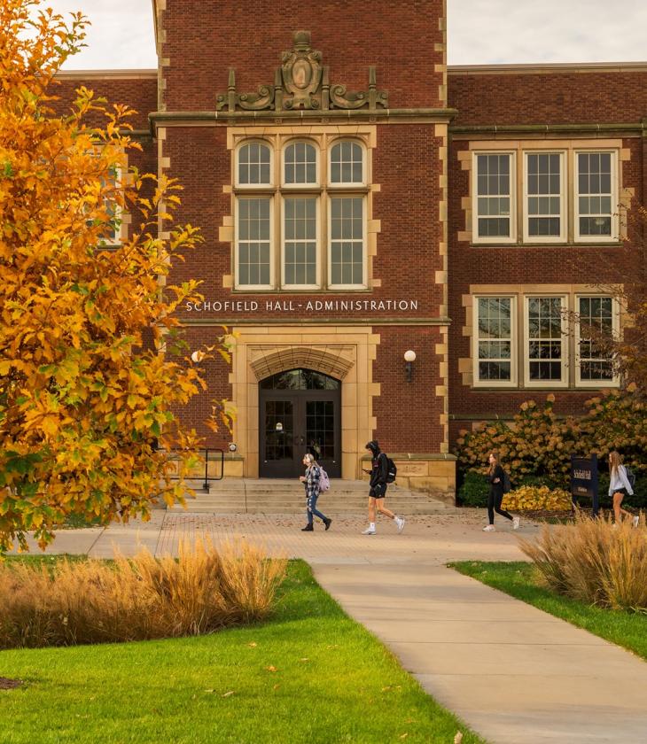 Schofield Hall in fall, from footbridge ramp
