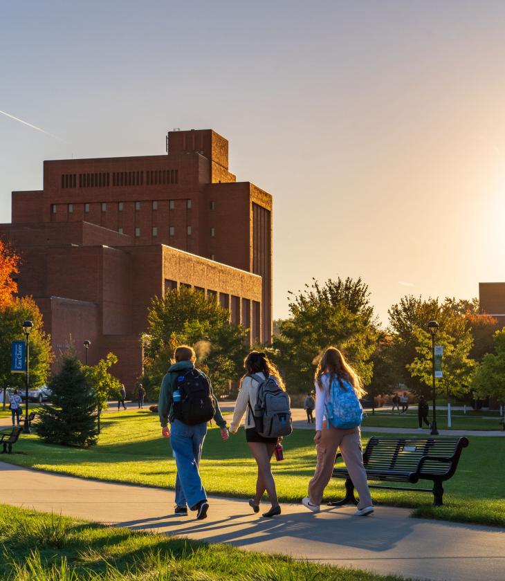 Students walk across campus as the fall sun sets.