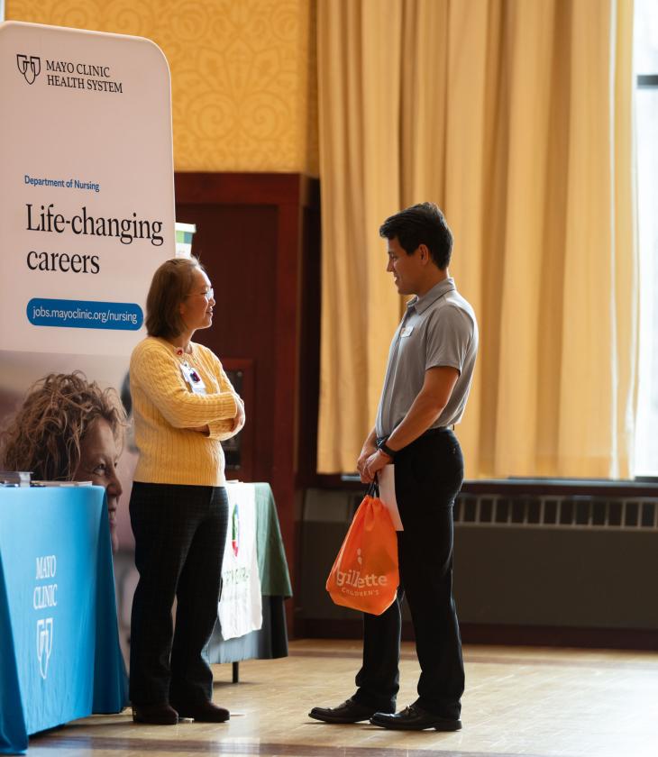 Student talks with a Mayo Clinic Health worker at the Health Career Fair