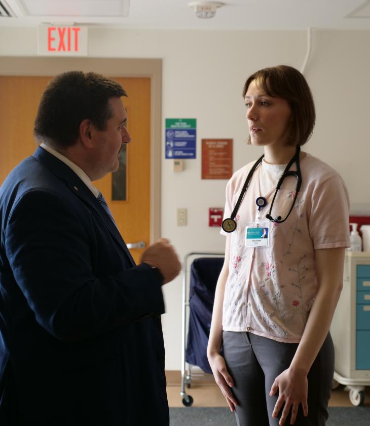 Public health student speaks with a doctor in a hospital hallway