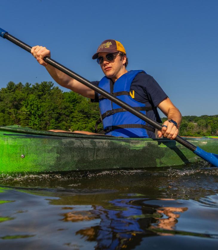 A student kayaks across the Chippewa River