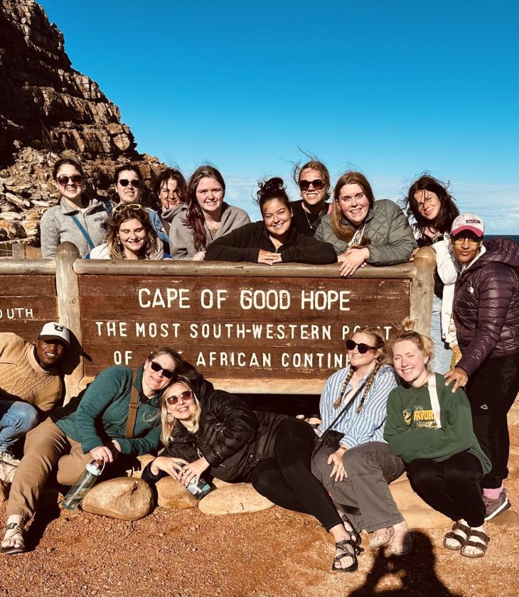 Students pose in front of a sign that reads "Cape of Good Hope"