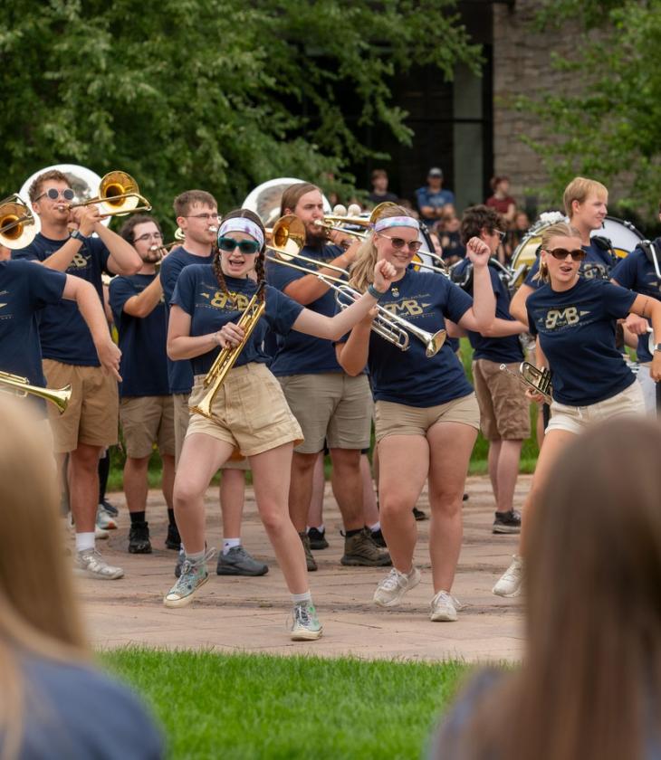 A group of Blugold Marching Band students play in front of a crowd on Opening Day.