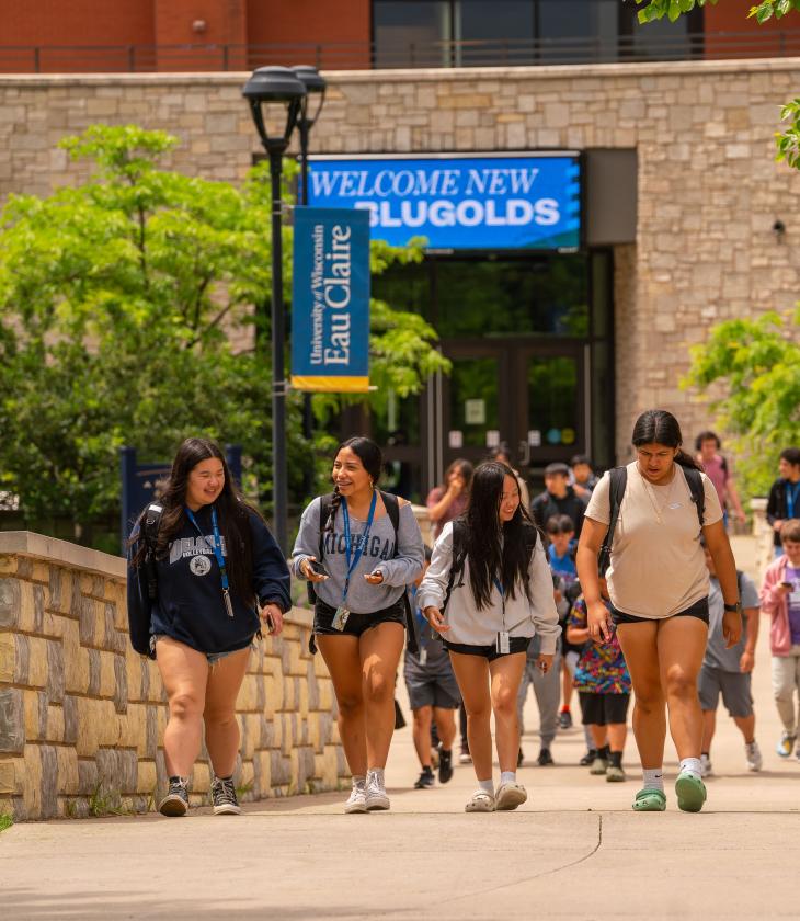 Students participating in Upward Bound walk across campus smiling and laughing.