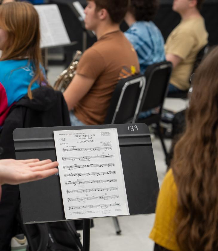 Students look at sheet music on a music stand